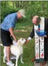  ?? TRACEY READ — THE NEWS-HERALD ?? Old South Church Pastor Ian Lynch blesses Archer, an English Lab, May 28 outside the Kirtland worship facility. At left is Waite Hill resident Bud Stanley.