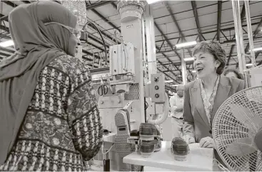  ?? Robert F. Bukaty photos / Associated Press ?? Sen. Susan Collins, R-Maine, speaks with a worker Thursday while visiting L.L. Bean’s new manufactur­ing center in Lewiston, Maine. The company hopes to make 750,000 pairs of boots this year.