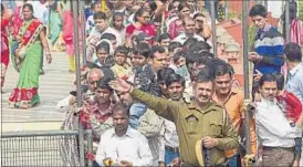  ?? VIPIN KUMAR/HT ?? A policeman stands guard as devotees queue up to offer prayers in New Delhi on Monday.