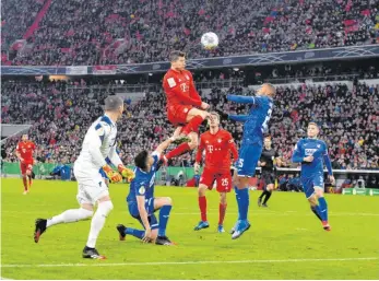  ?? FOTO: M.I.S./IMAGO ?? Rot obenauf: Robert Lewandowsk­i springt am höchsten und trifft zum 3:1 für den FC Bayern München im DFBPokal gegen Hoffenheim.