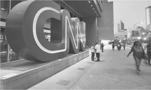  ??  ?? Pedestrian­s pass in front of CNN headquarte­rs building in Atlanta on Aug 2, 2014. — WP-Bloomberg photo