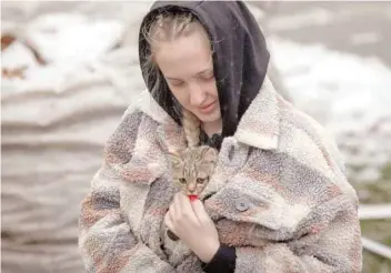  ?? Reuters ?? A local resident carries a kitten found in her flat in a residentia­l building destroyed by a Russian missile attack in the town of Vyshhorod, near Kyiv, Ukraine, on Thursday. —