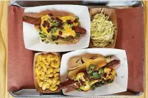  ?? Photos by Mike Sutter / Staff ?? The Bandit Dog at Bandit BBQ: A housemade brisket hot dog in a potato roll is topped with queso, bacon and green onions.