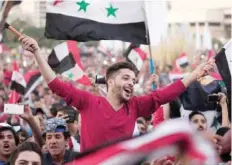  ?? — AFP ?? Syrians wave their national flag as they celebrate in Damascus’s Umayyad Square on October 5 after the national football team scored in the first leg of the Fifa World Cup 2018 qualifier between Syria and Australia.