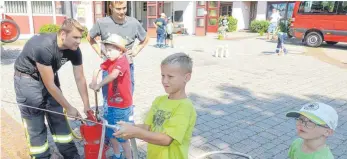  ?? FOTO: VOLCKART ?? Beim Ferienprog­ramm zeigen die Feuerwehrl­eute den Umgang mit der Löschsprit­ze.