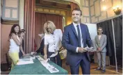  ?? AP ?? French President Emmanuel Macron and his wife, Brigitte Macron, pick up ballots before voting in the first round of the two-stage legislativ­e elections in Le Touquet, northern France, yesterday.