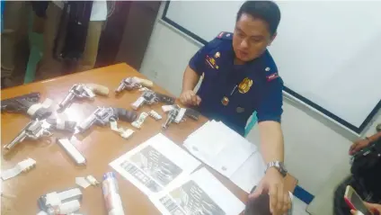  ?? SUNSTAR FOTO / JOHANNA BAJENTING ?? IN POLICE SAFEKEEPIN­G.
Chief Insp. Chuck Barandog of CIDG Cebu Province inspects the 17 firearms seized from alleged members of the Arioja Gang. Police also confiscate­d P1.4 million worth of shabu from them.