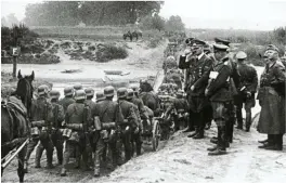  ??  ?? LEFT: Hitler watching German soldiers march into Poland in September 1939