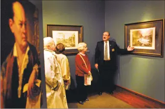  ??  ?? Jess Mallory, Knights of Columbus Museum staff assistant, right, talks about the etching “View of St. Peter’s Basilica And Piazza In The Vatican 1746-1748” as he gives a tour of the museum’s exhibit, “Etchings of the Eternal City, Piranesi’s Rome.”