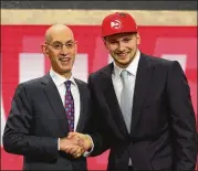  ?? MIKE STOBE / GETTY IMAGES ?? Luka Doncic poses with NBA Commission­er Adam Silver after being drafted by the Hawks, who traded his rights to Dallas for the rights to Trae Young and a pick.