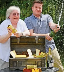  ??  ?? Golden touch: Vivian and son Colin celebrate with replica bullion