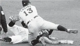 ?? KEITH SRAKOCIC/AP ?? Miami Marlins second baseman Starlin Castro tumbles over Pittsburgh Pirates’ Adam Frazier after tagging him as he was picked off second base by catcher Bryan Holaday in the fifth inning of Saturday’s game.