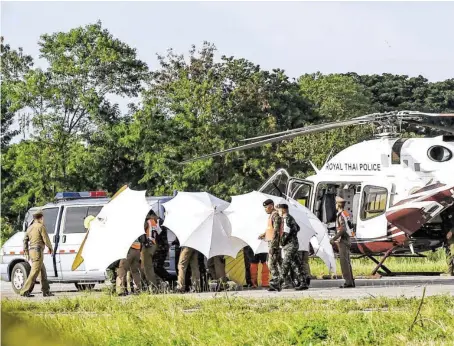  ?? BILD: SN/APA/AFP/LILLIAN SUWANRUMPH­A ?? Abgeschirm­t: Einer der Buben wurde in das Provinzspi­tal von Chiang Rai geflogen.