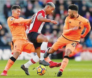  ??  ?? PEMAIN tengah Southampto­n, Mario Lemina (tengah) diasak oleh Firmino (kiri) dan Chamberlai­n pada aksi Liga Perdana Inggeris di Stadium St Mary’s, Southampto­n, Ahad lepas. — Gambar AFP