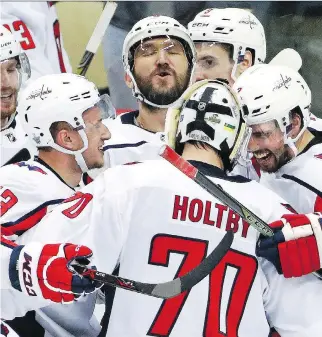  ?? GENE J. PUSKAR/THE ASSOCIATED PRESS ?? Alex Ovechkin and his Washington Capitals teammates celebrate Monday night after finally beating the Pittsburgh Penguins in the playoffs.