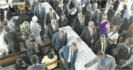  ?? (Photos: Jason Tulloch) ?? Pall-bearers carry the caskets of Dawnette Turner and Lily Gaynor outside of the church.