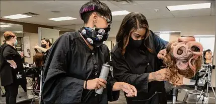  ??  ?? Students Gabrielle Harris, above left, and Quanessa Nobles work on the hair of a mannequin for an avant-garde project in the cosmetolog­y classroom at the Capital District Educationa­l Opportunit­y Center in Troy. Student Imtiage Marup, left, originally from Bangladesh, puts precision into an electrical project in the building trade classroom at the center.