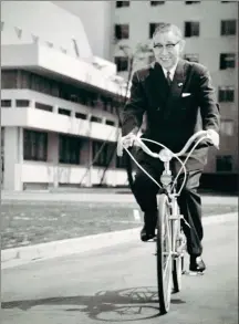  ?? COURTESY OF PANASONIC CORP ?? Konosuke Matsushita rides a bicycle at a Matsushita Electric factory.