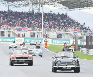  ??  ?? Mercedes’ British driver Lewis Hamilton (left) and McLaren’s Spanish driver Fernando Alonso together with all the Formula one driver drives their car and waves to Malaysian fan during the Formula One Malaysia Grand Prix in Sepang. — AFP photo