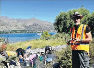  ?? PHOTO: KERRIE WATERWORTH ?? Revitalisi­ng a resource . . . Organiser Richard Windelov holds a water goddess sculpture he made for the Wanaka community spring as volunteers remove stones and debris from the spring pond beside Lakeside Rd.