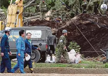  ?? AFP PIC ?? Japanese Prime Minister Shinzo Abe (second from left) visiting the devastated city of Atsuma yesterday.