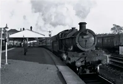  ?? COLOUR RAIL ?? A sight not seen at Tyseley station for over 50 years… On September 26 1963 No. 6877 Llanfair Grange runs through the outskirts of Birmingham with a Wolverhamp­ton train.