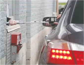  ?? TONY CALDWELL ?? A pole provides physical distancing for making a payment at a drive-thru in Ottawa Monday.