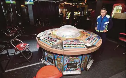  ??  ?? Policemen conducting a raid on an illegal online gambling den in Kuala Lumpur last year.