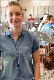  ??  ?? A Pea Ridge FFA student poses with hens at a show.