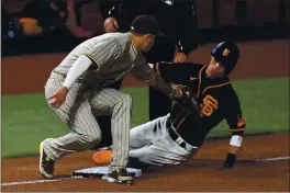 ?? JOSE CARLOS FAJARDO — BAY AREA NEWS GROUP ?? The Giants’ Mauricio Dubon is tagged out by San Diego Padres’ Manny Machado while attempting to steal third base on Saturday.