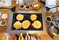  ?? ?? ABOVE: Pancakes are prepared by diners on tabletop griddles at the Old Spanish Sugar Mill restaurant in De Leon Springs State Park.