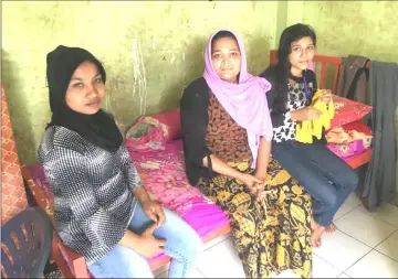  ??  ?? Sharifa Begum, 15, a refugee, sits alongside the Rohingya family that adopted her at a migrants accommodat­ion block in Medan, Indonesia, Feb 238. — Reuters photos