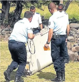  ?? AFP ?? Trozo. Lo que sería parte de un ala, en manos de la policía local.