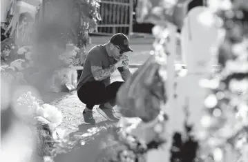  ?? ERIC GAY AP ?? A man pays his respects at a memorial outside Robb Elementary School on Thursday in Uvalde, Texas.