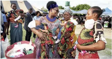  ??  ?? FIRST Lady Esther Lungu yesterday presented gifts to triplets in Kitwe during the official hand over of Kafue Bridge Secondary School that has been named after her to the Ministry of General Education.
- Picture by THOMAS NSAMA.