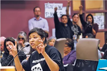  ??  ?? Ahjani Yepa, a Jemez Pueblo member, testifies in opposition of a proposed ordinance that would govern oil and gas developmen­t in Sandoval County as others raise their fists in solidarity Thursday night during a County Commission meeting in Bernalillo....