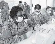  ?? AL DIAZ adiaz@miamiheral­d.com ?? Taeja Lee, a U.S. Army pharmacy technician, prepares a COVID-19 vaccine on Wednesday at Miami Dade College’s North Campus.