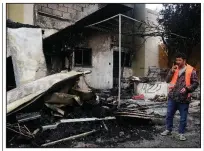  ?? (AP/Alexandros Michailidi­s) ?? A man stands Sunday next to a fire-damaged migrant center on the island of Lesbos, Greece. More photos at arkansason­line. com/39greece/.