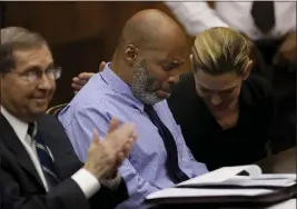  ?? CHRISTIAN GOODEN — ST. LOUIS POST-DISPATCH VIA AP ?? Lamar Johnson, center, and his attorneys react on Tuesday after Circuit Judge David Mason vacated his murder conviction during a hearing in St. Louis, Mo.