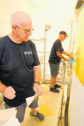  ??  ?? Vern Newlove and John Ferguson apply some of the $50,000 of gold leaf being put on to cupola (dome) that will go atop the Hundertwas­ser Art Centre in Whanga¯ rei.