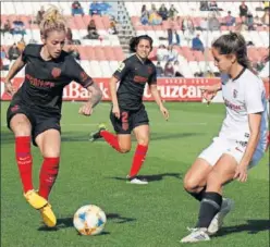  ??  ?? Ángela Sosa, del Atleti, protege el balón ante la presión del Sevilla.