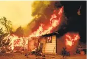  ?? ETHAN SWOPE AP ?? Flames consume a house near Old Oregon Trail as the Fawn fire burns north of Redding on Thursday.