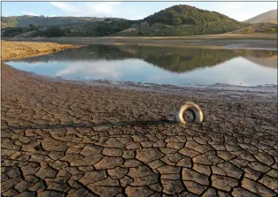  ?? JUSTIN SULLIVAN — GETTY IMAGES ?? A tire is wedged between cracks in dry earth at the Nicasio Reservoir in the summer of 2021. In May 2021, Gov. Gavin Newsom expanded California's drought emergency to 41 out of 58counties and statewide by October 2021.