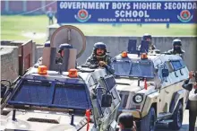  ?? Reuters ?? Security forces keep guard atop armoured vehicles, outside a government school after suspected militants shot and killed two teachers in Srinagar.