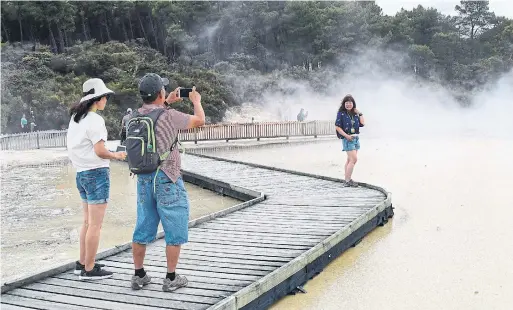  ?? M.L. LYKE PHOTOS ?? A boardwalk crosses the steaming pool at Wai-O-Tapu. The Rotorua region is one of the world’s most geothermal­ly active areas.