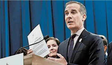  ?? RICH PEDRONCELL­I/AP ?? Los Angeles Mayor Eric Garcetti instituted a city shutdown and threatened businesses with power shutoffs and arrests.