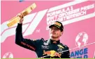  ??  ?? Red Bull’s Max Verstappen holds his award on the podium after winning the Austrian Grand Prix