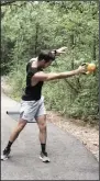  ?? (Arkansas Democrat-Gazette/Celia Storey) ?? Eric Godwin does the Lateral KB Swing on a trail near Little Rock Athletic Club, where the certified personal trainer sees his clients.