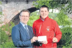  ??  ?? Councillor Alexander Stewart presents the cheque to Robert.