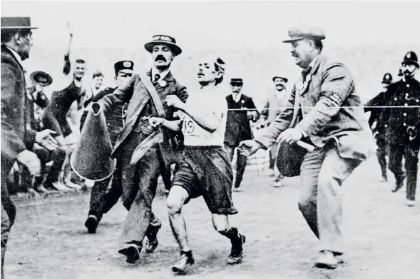  ?? PHOTOGRAPH: IOC/ALLSPORT ?? ▼ Dorando Pietri of Italy is helped to the finishing line after collapsing during the London Games in 1908